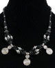 Collier ethnique artisanal perles noires agencees d'agrements argentes garni de grandes breloques spirales en metal argente