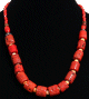 Collier ethnique un rang de pieces imitation corail rouge agencees de perles jaunes et rouges agremente de disques argentes