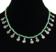 Collier ethnique imitation perles vertes agencees de perles argentees et autres en bois, agremente de petites breloques tourbillon spirale en metal argente