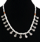 Collier artisanal imitation perles blanches agencees de perles argentees et autres en bois, agremente de petites breloques tourbillon en metal argente
